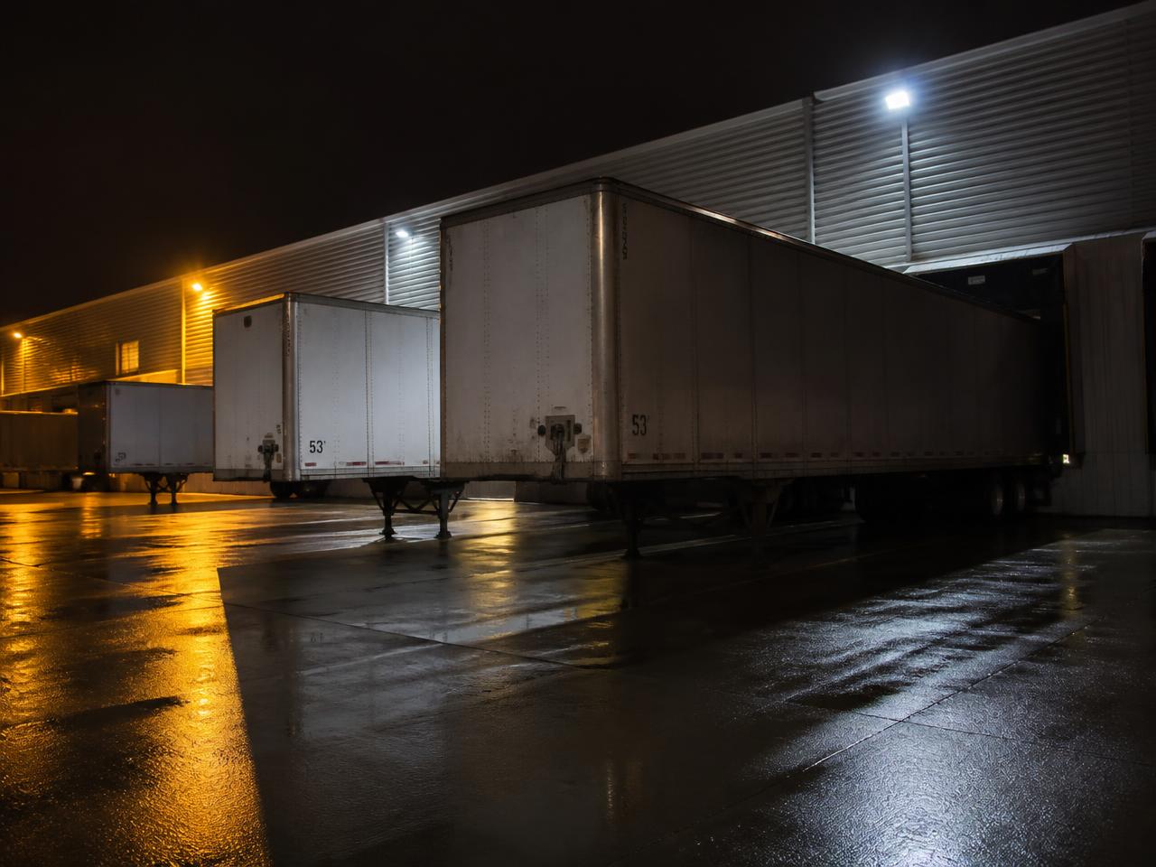 Trailers backed into a lit loading dock at night